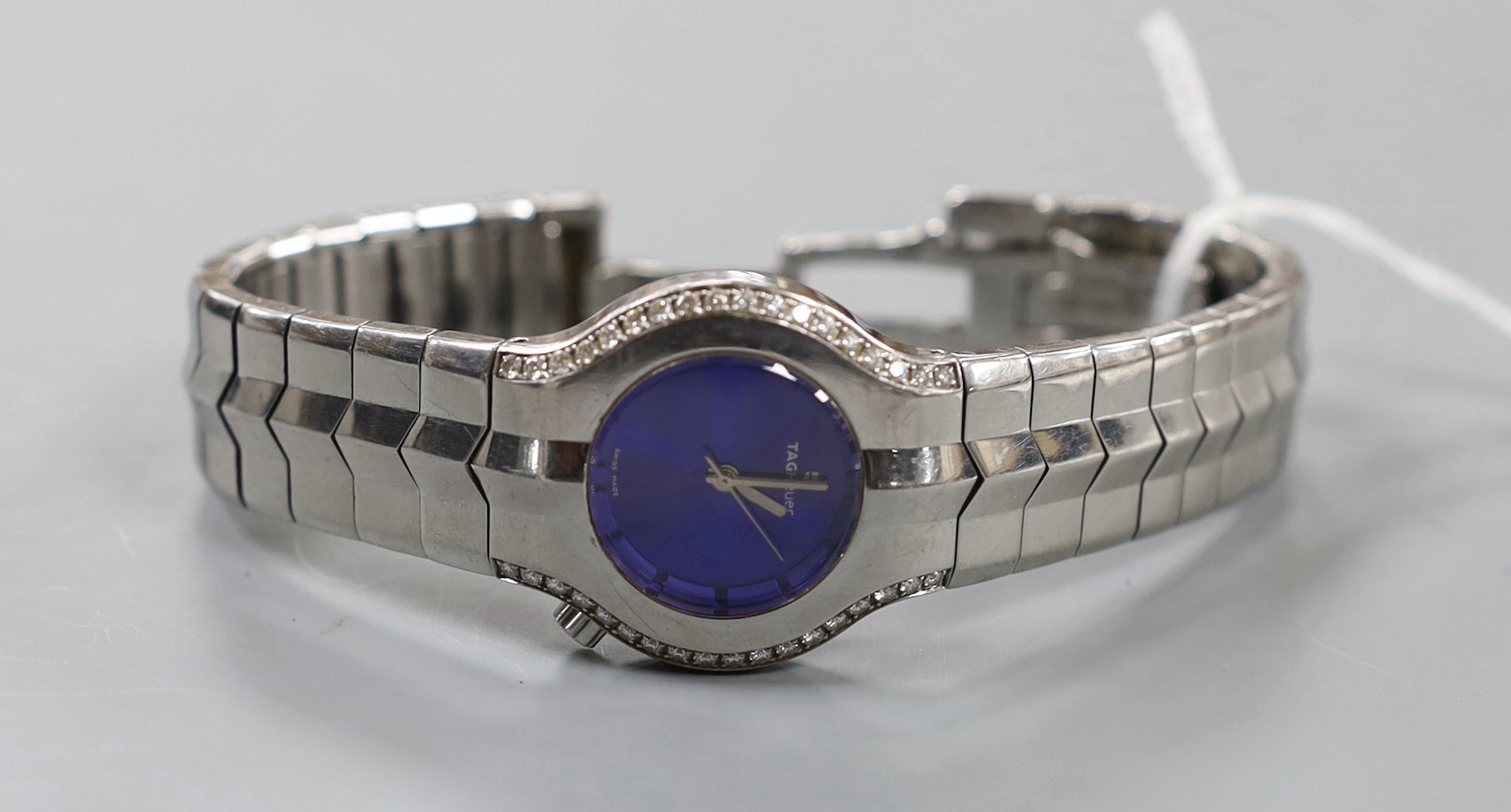 A lady's stylish modern steel Tag Heuer quartz wrist watch and bracelet, with blue dial and diamond chip set bezel, with boxes.